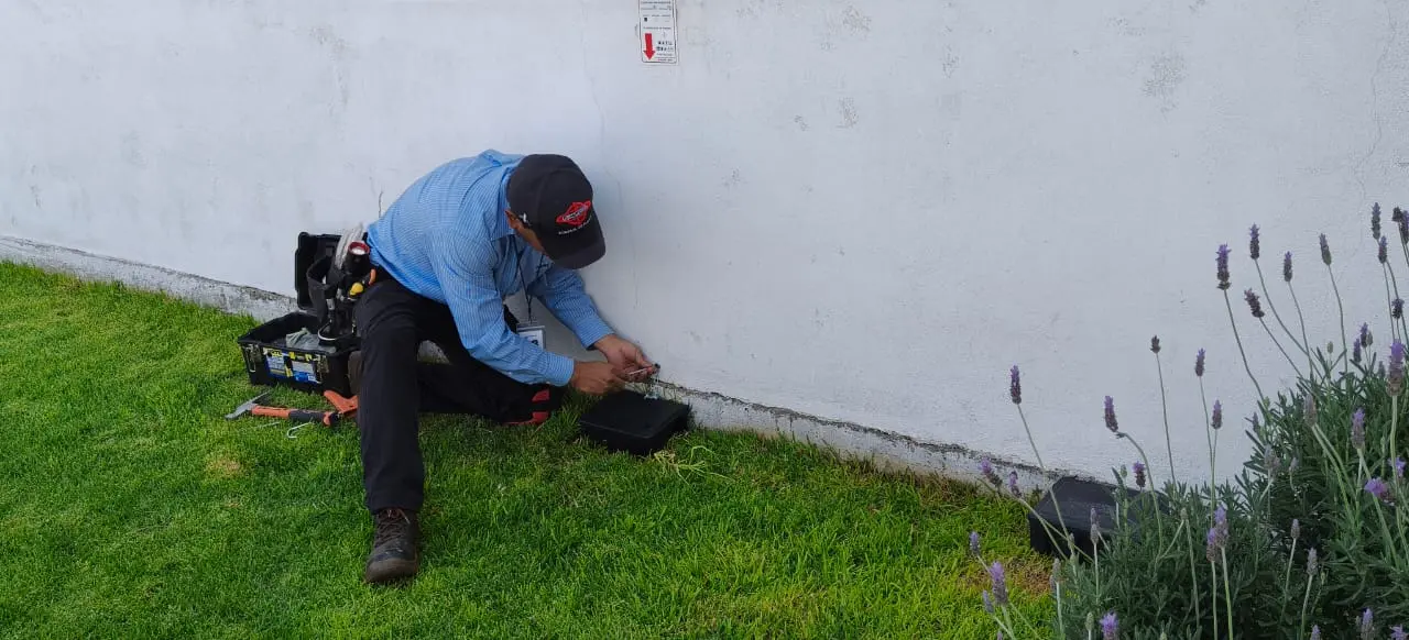 Técnico de FUMIESCAL instalando una estación de control en un área exterior